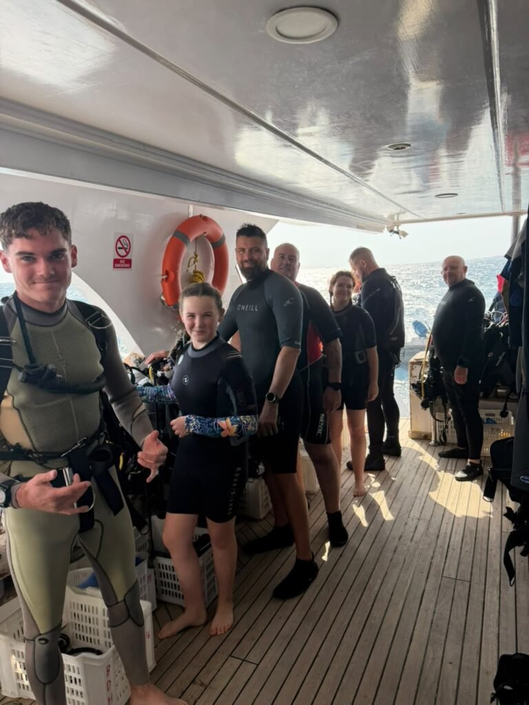 Divers in wetsuits on the dive deck