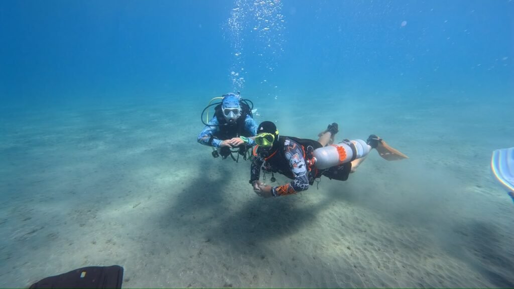 Instructor and diver over the sand