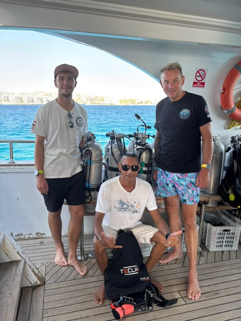 Three men on the boat deck with dive kit